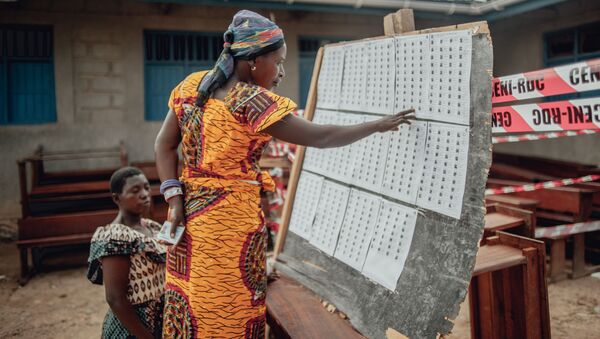 Une femme cherche son nom sur les listes électorales de la CENI en RDC. - Sputnik Afrique