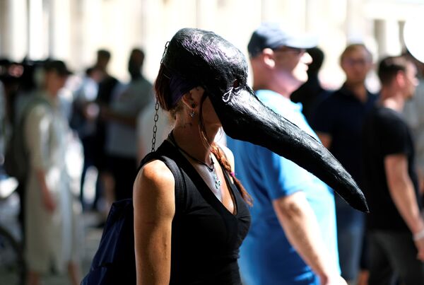 Une jeune femme portant un masque de médecin de peste pendant une manifestation contre les restrictions imposées pour lutter contre le Covid-19, Berlin. - Sputnik Afrique