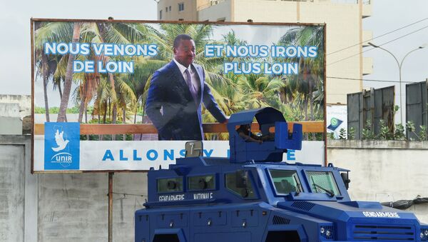 Un véhicule de l'armée togolaise garé devant une affiche électorale du Président Faure Gnassingbé - Sputnik Afrique