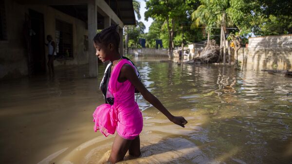 Девочка идет по затопленной после урагана улице на Гаити - Sputnik Afrique