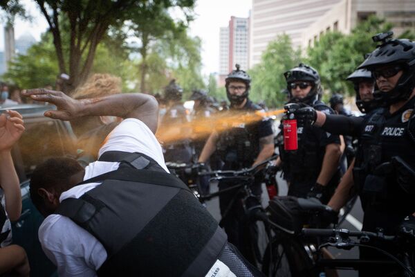 Un policier disperse du gaz lacrymogène sur des manifestants, Charlotte, Caroline du Nord.  - Sputnik Afrique