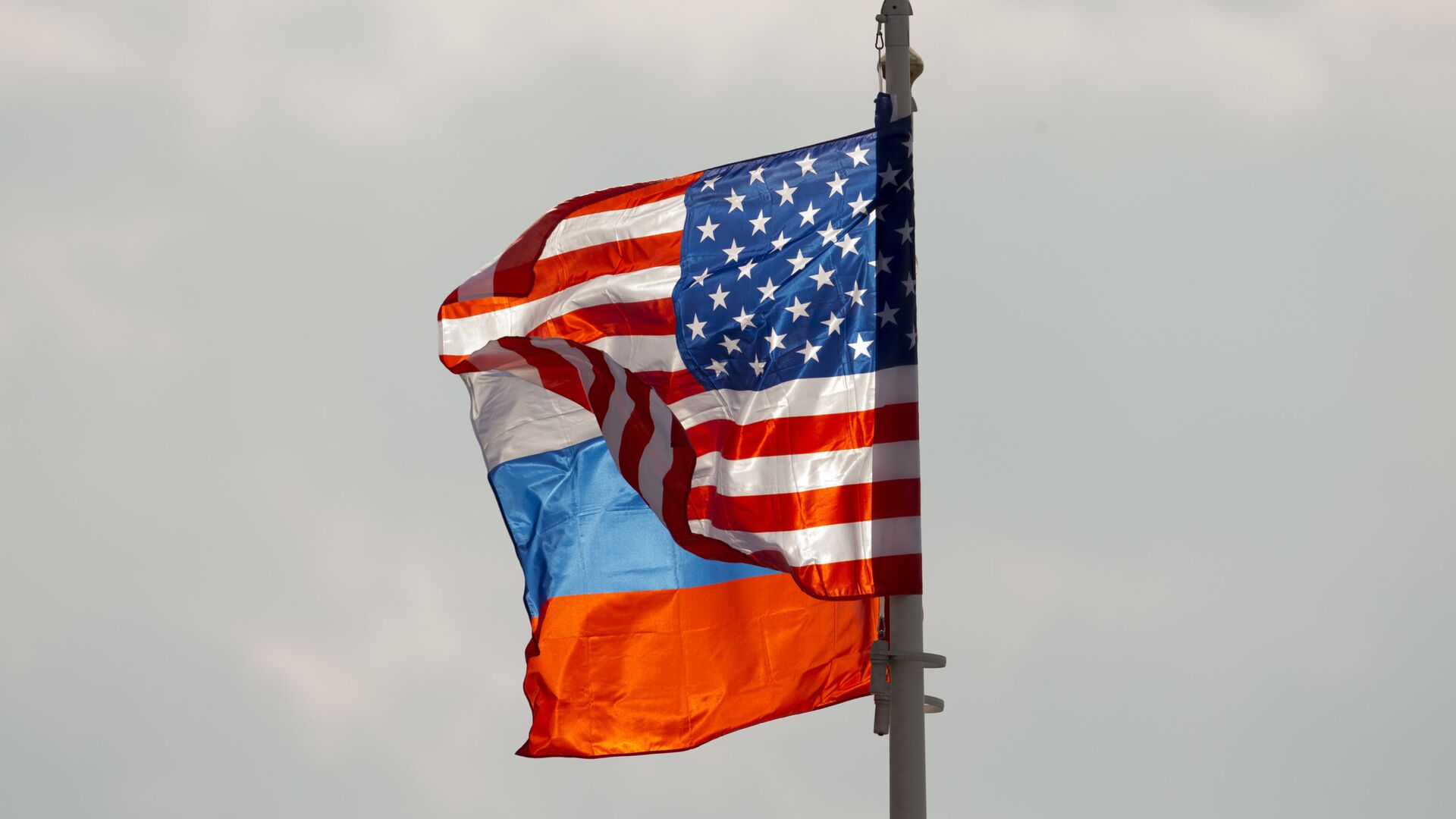 DOSSIER - dans ce dossier du mardi 11 avril 2017, photo des drapeaux nationaux américain et russe flottant au vent avant l'arrivée du secrétaire d'État américain Rex Tillerson à l'aéroport de Moscou Vnukovo, en Russie. Vendredi 1er septembre 2017, la Russie a promis une réponse ferme après que les États-Unis aient donné l'ordre de fermer le consulat russe à San Francisco et les bureaux à Washington et New York et aient donné à la Russie 48 heures pour s'y conformer, ce qui a intensifié les tensions entre les deux pays. (AP Photo/ Ivan Sekretarev, dossier) - Sputnik Afrique, 1920, 04.02.2021