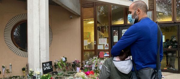 Des enseignants déposent des fleurs devant le collège du Bois d’Aulne à Conflans-Sainte-Honorine en hommage à Samuel Paty, décapité le 16 octobre  - Sputnik Afrique