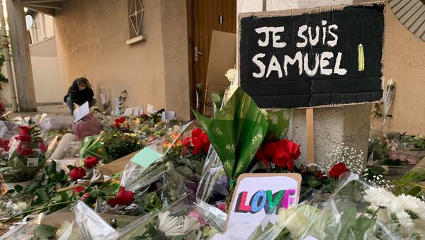 Des enseignants déposent des fleurs devant le collège du Bois d’Aulne à Conflans-Sainte-Honorine en hommage à Samuel Paty, décapité le 16 octobre  - Sputnik Afrique