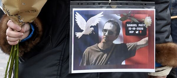 Une femme tient une photo de Samuel Paty - Sputnik Afrique