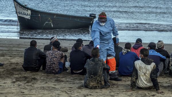 Мигрантам из Марокко проверяют температуру после прибытия на побережье Канарских островов - Sputnik Afrique