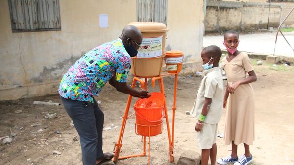 Un enseignant, montrant aux enfants comment se laver les mains - Sputnik Afrique