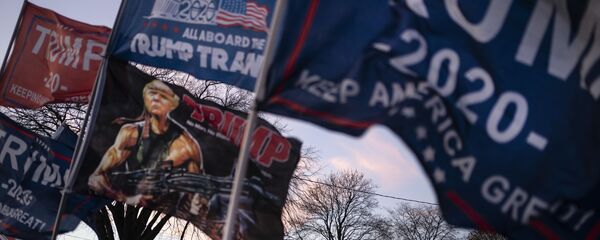 People are silhouetted as they wait to board shuttle buses to a rally for President Donald Trump, Monday, Nov. 2, 2020 - Sputnik Afrique