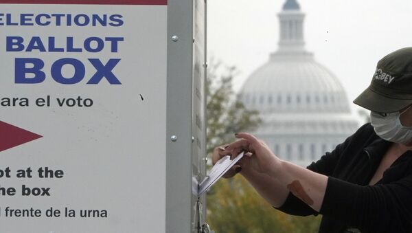 Le dôme du Capitole à l'horizon, un électeur dépose son bulletin dans une boîte de dépôt de votes anticipés, le 28 octobre, Washington - Sputnik Afrique