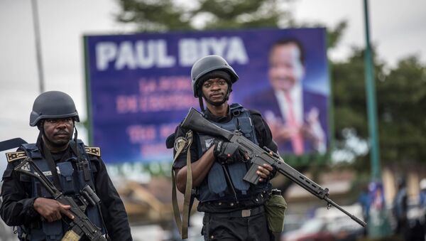 Des militaires camerounais devant une affiche de Paul Biya - Sputnik Afrique