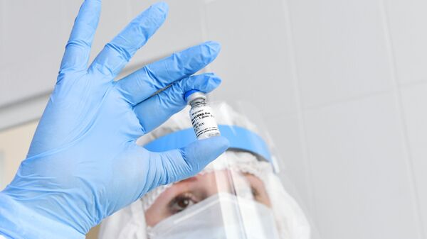 Une infirmière tient une ampoule contenant le vaccin Spoutnik V - Sputnik Afrique