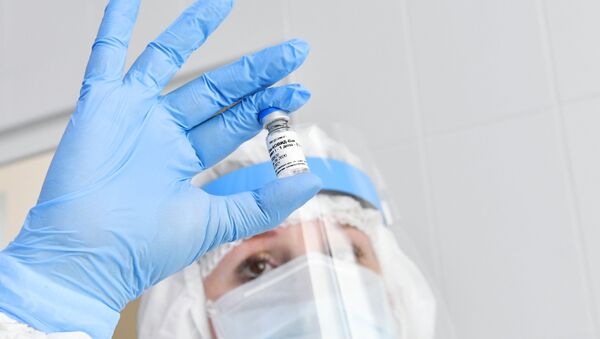 Une infirmière tient une ampoule contenant le vaccin Spoutnik V - Sputnik Afrique