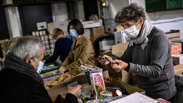 Un volontaire de l'association «Les Restos du Coeur» distribue de la nourriture à Paris - Sputnik Afrique