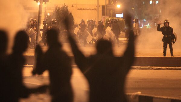 Egyptian protesters gesture as they clash with riot police at Cairo's landmark Tahrir Square on November 19, 2011, as Egyptian police fired rubber bullets and tear gas to break up a sit-in among whose organisers were people injured during the Arab Spring which overthrew veteran president Hosni Mubarak - Sputnik Afrique