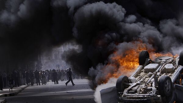 Горящий автомобиль, подожженный антиправительственными демонстрантами во время беспорядков в Сане, Йемен, 2011 год - Sputnik Afrique