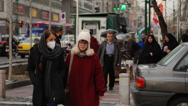 Des habitants de Téhéran marchent dans une rue centrale en portant des masques médicaux. Les autorités iraniennes ont annoncé pour la première fois l'infection par le coronavirus le 19 février. L'infection a commencé dans la ville de Qom, un lieu de pèlerinage pour les musulmans chiites. - Sputnik Afrique