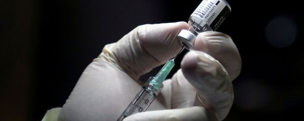 Un médecin se prépare à administrer une dose du vaccin de Pfizer/BioNTech (archive photo) - Sputnik Afrique