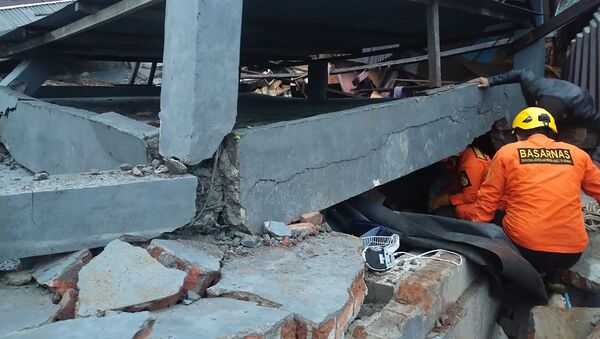 Les sauveteurs recherchent les survivants sous les décombres des bâtiments détruits par le séisme sur l'île indonésienne de Célèbes - Sputnik Afrique