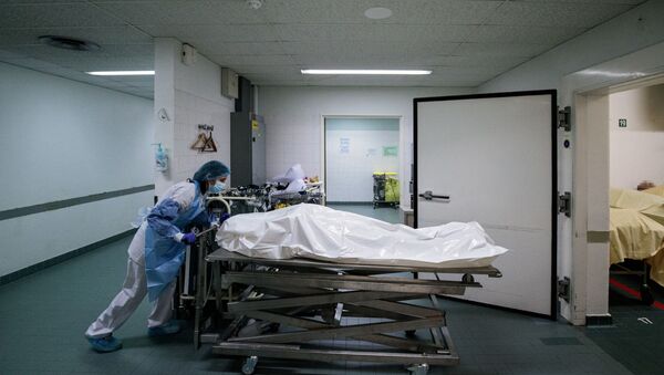 Un membre du personnel médical déplace le corps d'un patient décédé du Covid-19. - Sputnik Afrique