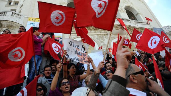 Des Tunisiens brandissent des drapeaux du pays lors d'une manifestation à Tunis (archives) (Photo by FETHI BELAID / AFP) - Sputnik Afrique