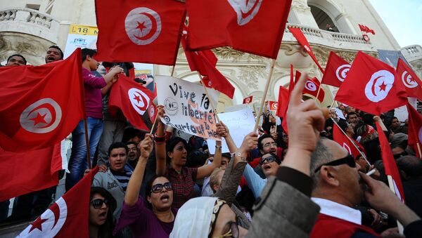 Des Tunisiens brandissent des drapeaux du pays lors d'une manifestation à Tunis (archives) - Sputnik Afrique
