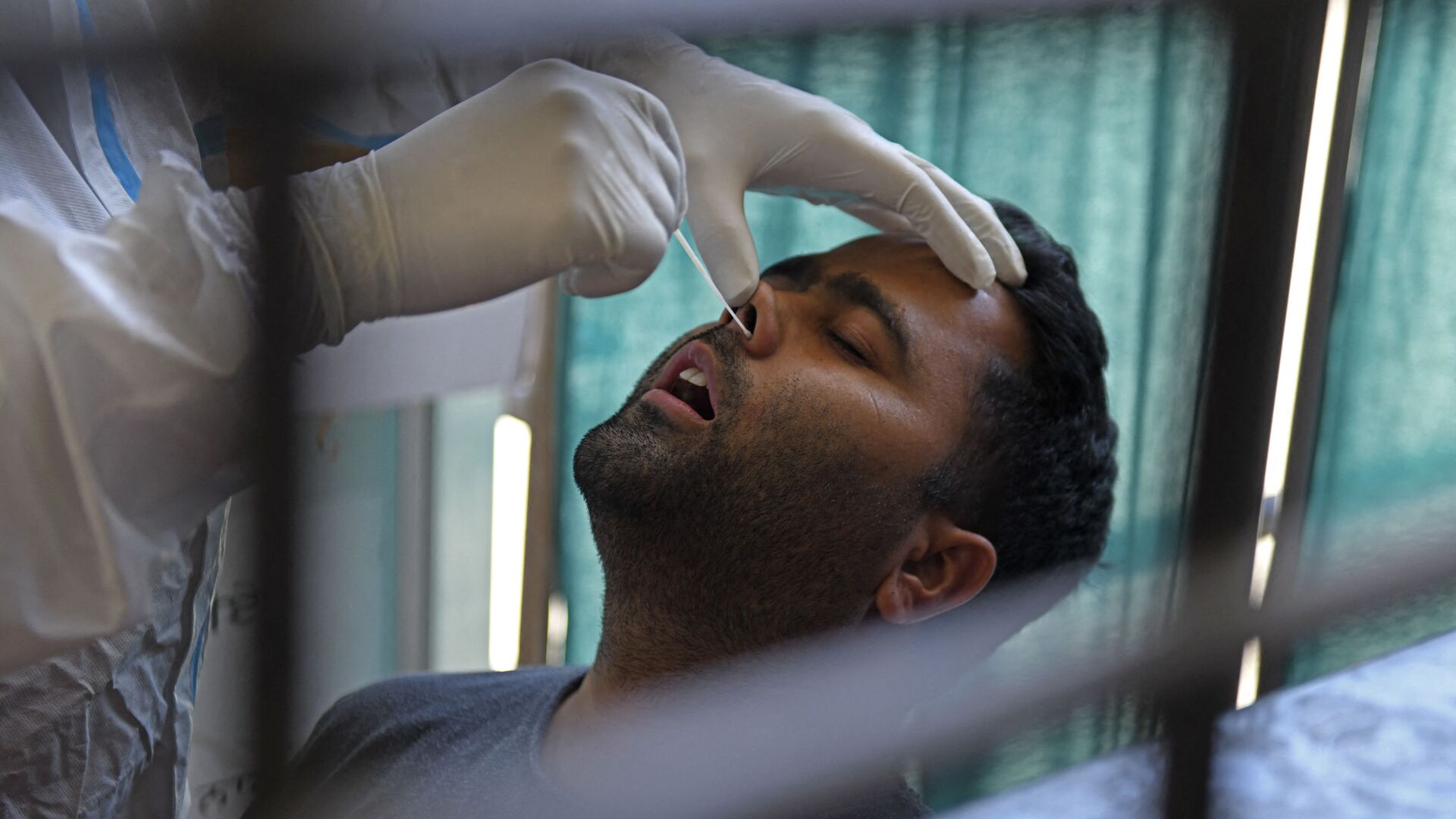 Un agent de santé prélève un échantillon par écouvillonnage nasal sur un homme pour tester le coronavirus Covid-19 à Amritsar en Inde, le 18 avril 2021. - Sputnik Afrique, 1920, 21.06.2021