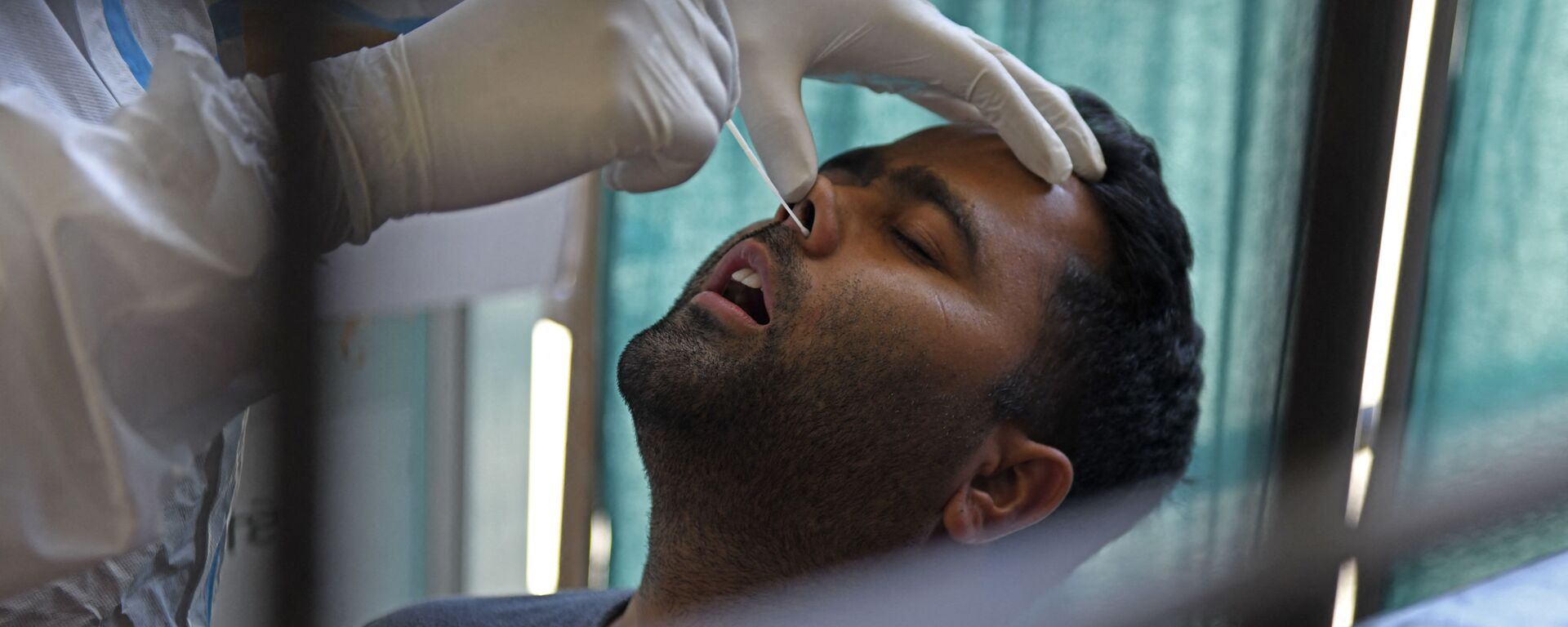 Un agent de santé prélève un échantillon par écouvillonnage nasal sur un homme pour tester le coronavirus Covid-19 à Amritsar en Inde, le 18 avril 2021. - Sputnik Afrique, 1920, 03.05.2021