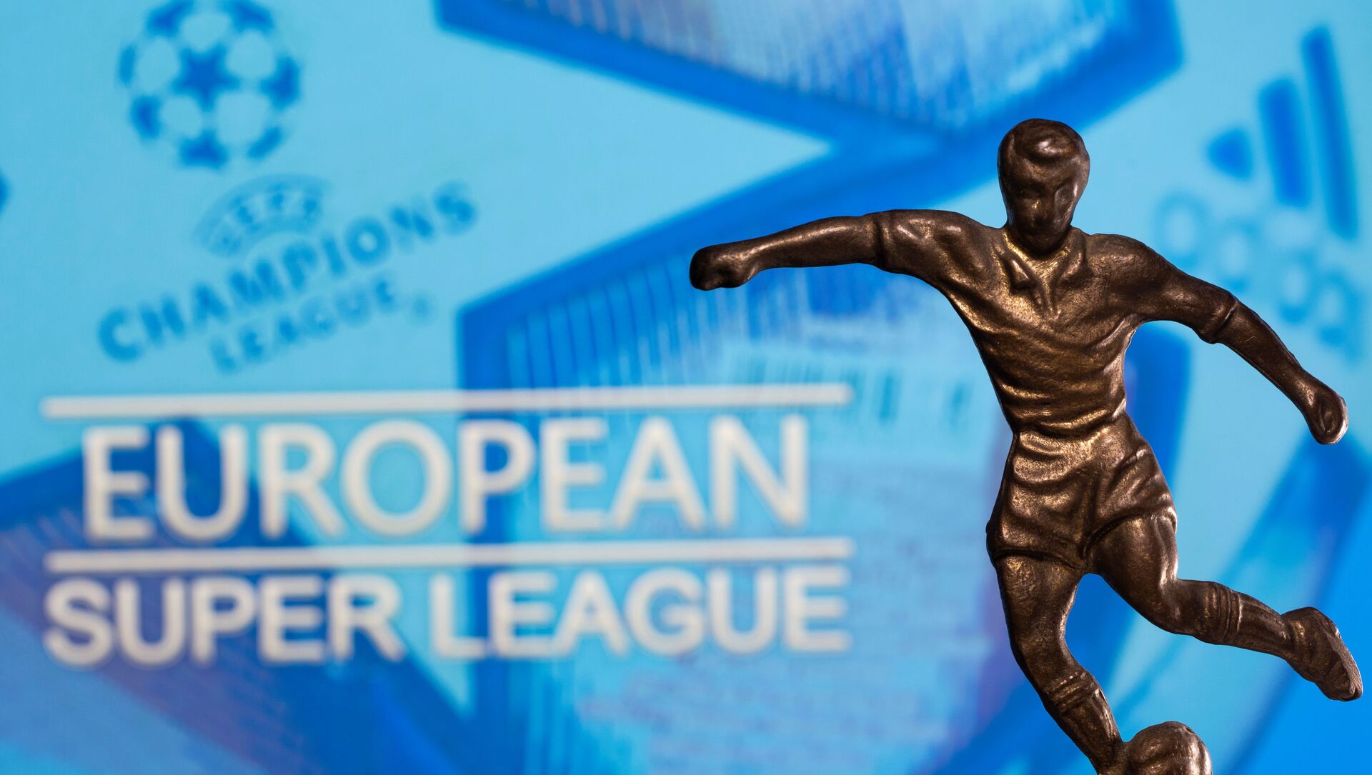 A metal figure of a football player with a ball is seen in front of the words European Super League and the UEFA Champions League logo in this illustration taken April 20, 2021 - Sputnik Afrique, 1920, 21.04.2021