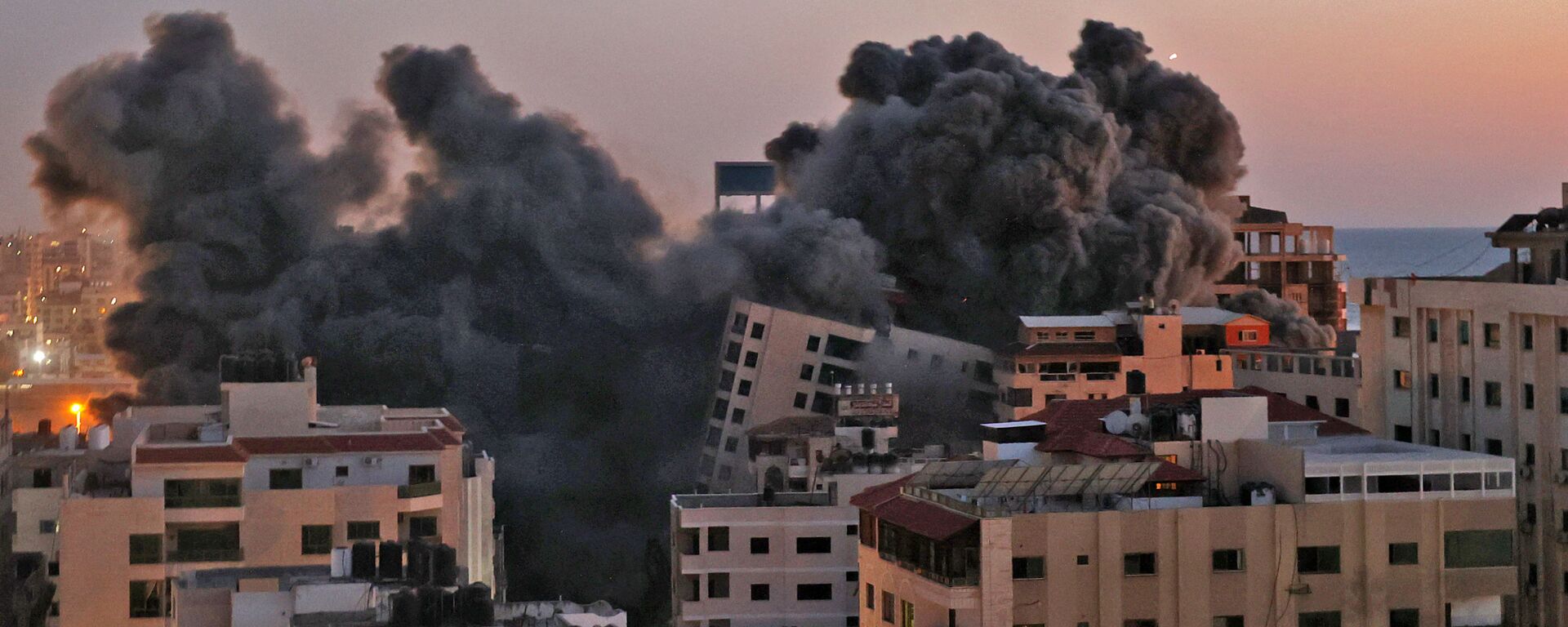 Пожарные тушат горящие многоквартирные дома после израильских авиаударов в городе Газа - главная - Sputnik Afrique, 1920, 18.05.2021
