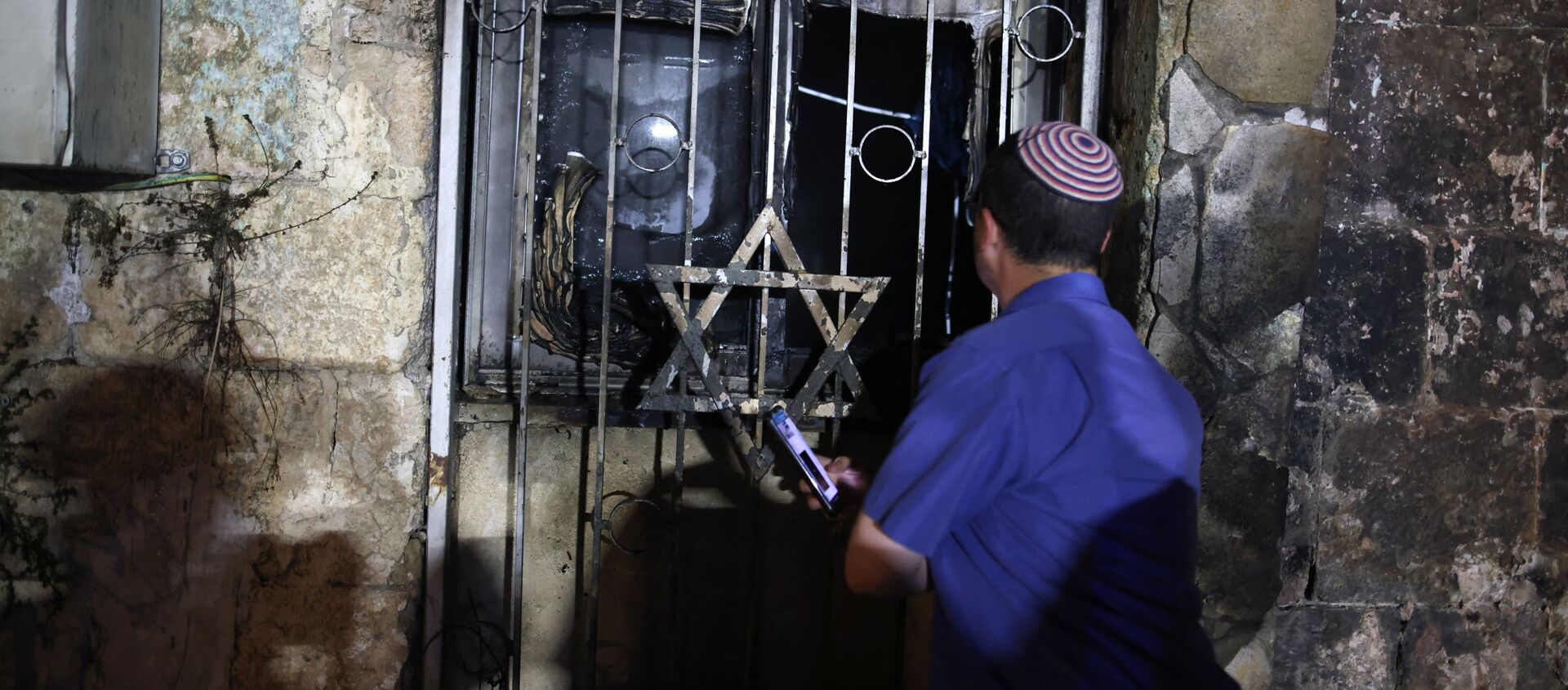 An Israeli man looks inside a synagogue, after it was set on fire by Arab-Israelis, in the mixed Jewish-Arab city of Lod on May 14, 2021, during clashes between Israeli far-right extremists and Arab-Israelis - Sputnik Afrique, 1920