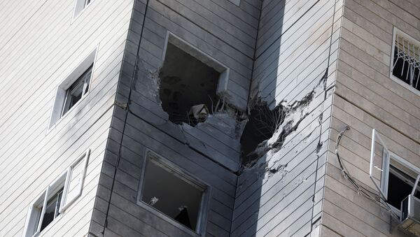 Un immeuble endommagé par une roquette tirée depuis la bande de Gaza, à Ashkelon, le 11 mai 2021 - Sputnik Afrique