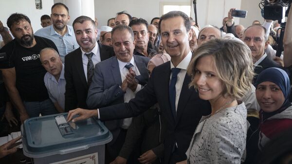 Le Président syrien Bachar el-Assad et sa femme Asma dans un bureau de vote lors de l'élection présidentielle, dans la ville de Douma, située dans la région de la Ghouta, tout proche de la capitale Damas, mercredi 26 mai, 2021 - Sputnik Afrique