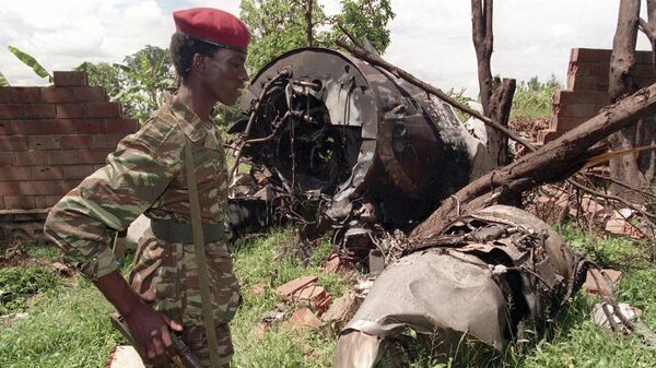 Un militaire rebelle du FPR (Front patriotique rwandais) de Paul Kagame (Tutsi) devant l'épave du Falcon 50 abattu par un tir de missile au-dessus de l'aéroport de Kigali, capitale du Rwanda, le 6 avril 1994. L'avion transportait le Président de la République rwandaise alors en exercice, Juvénal Habyarimana (Hutu), ainsi que son homologue du Burundi, Cyprien Ntaryamira.  - Sputnik Afrique
