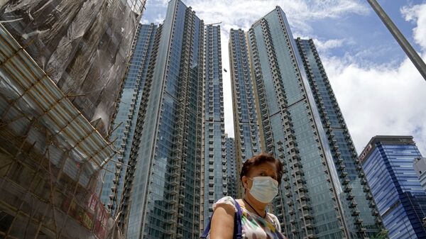 Женщина в маске напротив жилого комплекса в Гонконге  - Sputnik Afrique