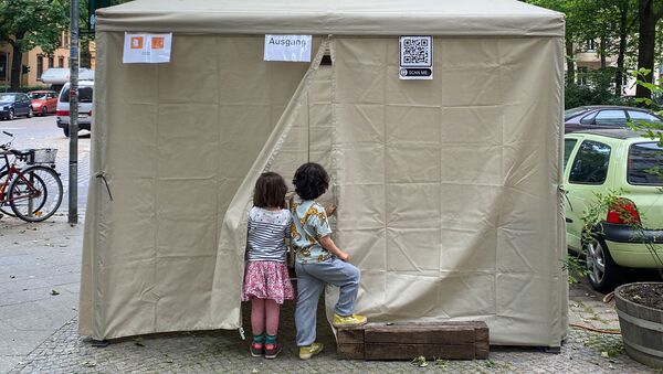 Deux enfants attendent leurs parents devant un lieu de dépistage du Covid-19, à Berlin en Allemagne - Sputnik Afrique