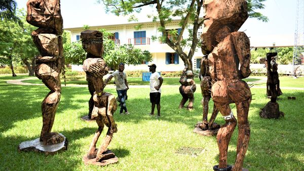 Devant les sculptures sous le titre de l'humanité, l'Atisso Goha échange avec un autre visiteur - Sputnik Afrique