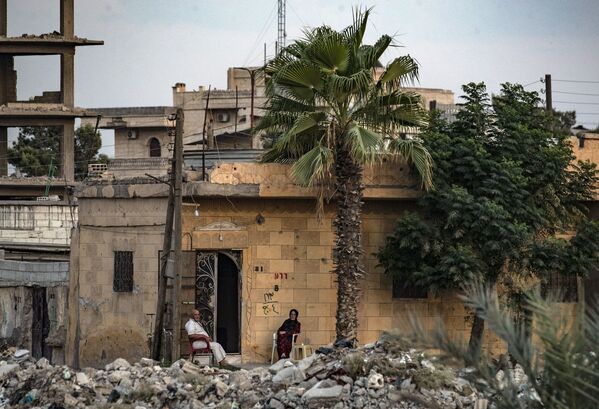 Des habitants devant leur maison détruite à Raqqa, en Syrie. - Sputnik Afrique