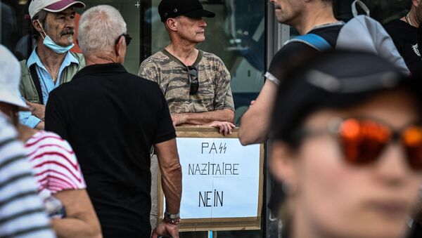 un manifestant avec une pancarte «PaSS nazitaire nein» à Lyon - Sputnik Afrique