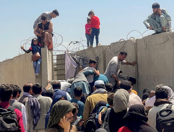 Des milliers de personnes tentent de prendre l'avion à l'aéroport de Kaboul afin de quitter le pays. Gardé par l'armée américaine, l'aéroport est désormais la seule voie possible pour ceux qui veulent partir. - Sputnik Afrique