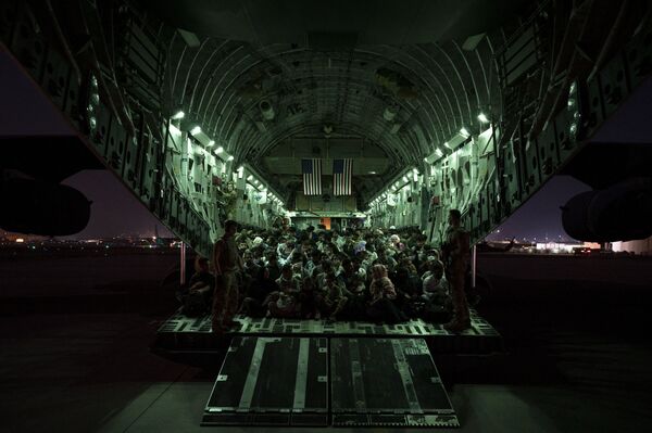 Selon Joe Biden, les États-Unis ont évacué environ 33.000 personnes d'Afghanistan depuis début juillet. Environ 28.000 d'entre elles ont quitté le pays après le 14 août. À l'avenir, les autorités américaines prévoient d'utiliser des vols commerciaux pour transporter les évacués des bases militaires.Sur la photo: réfugiés afghans à bord d'un avion américain C-17 Globemaster III à l'aéroport de Kaboul le 21 août 2021. - Sputnik Afrique