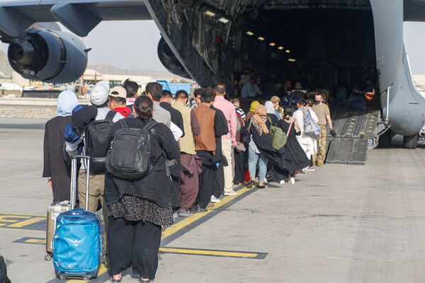 La situation à l'aéroport de Kaboul reste agitée. Le matin du 23 août, une fusillade a éclaté entre des combattants et des gardes afghans à la porte nord de l'aéroport. Un Afghan a été tué et trois autres ont été blessés. Des militaires américains et allemands ont également pris part à l'escarmouche.Sur la photo: des réfugiés afghans embarquent dans un avion de l'US Air Force à l'aéroport international de Kaboul le 18 août 2021. - Sputnik Afrique