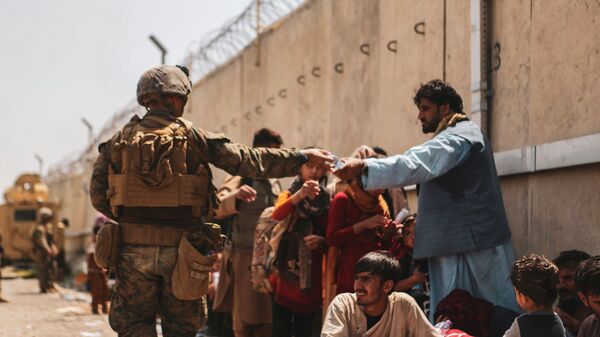 A US Marine passes out water to evacuees during an evacuation at Hamid Karzai International Airport, Kabul, Afghanistan, August 22, 2021 - Sputnik Afrique
