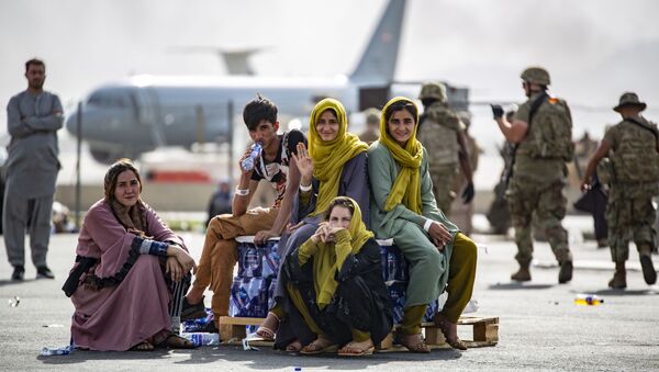 Sur cette image fournie par l'US Marine, des enfants attendent d'être évacués à l'aéroport de Kaboul, Afghanistan, Jeudi 19 août 2021 - Sputnik Afrique