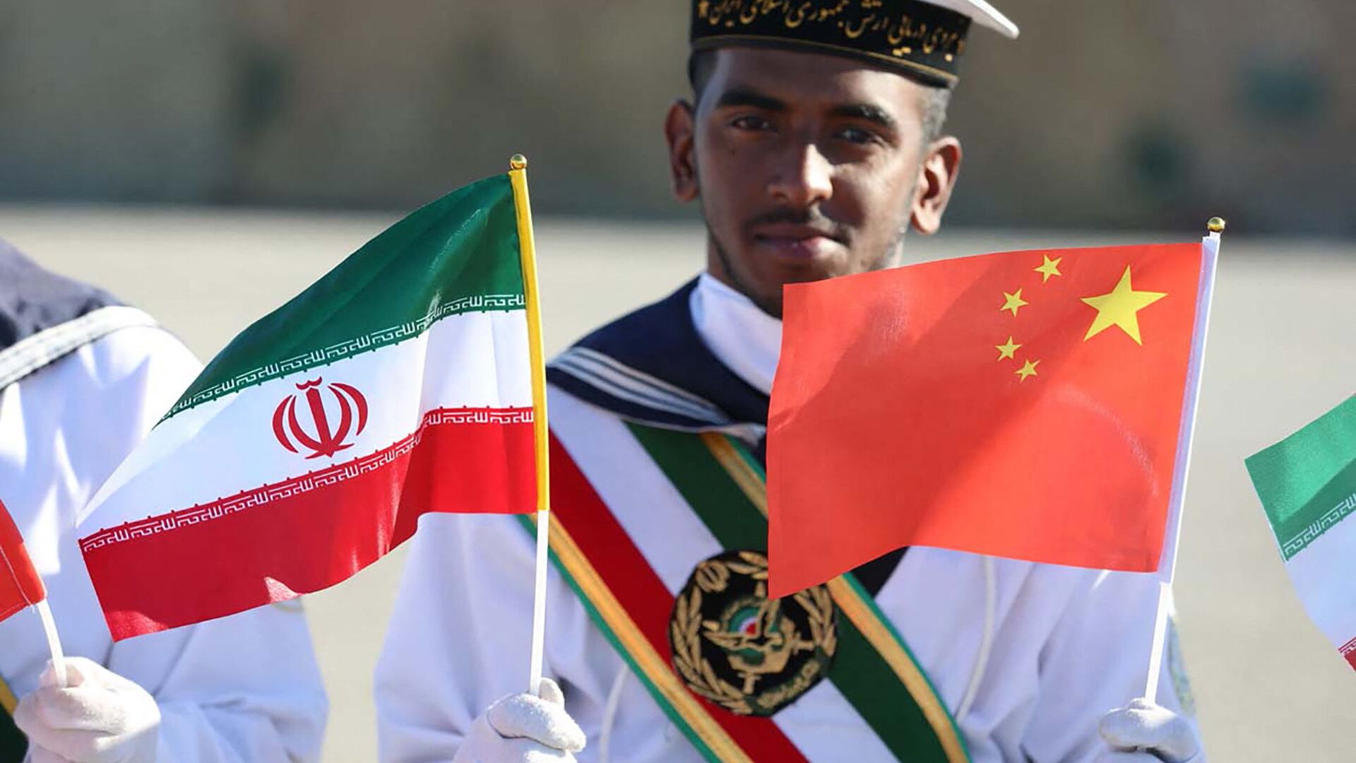 montre un marin iranien brandissant les drapeaux nationaux iranien et chinois lors d'une cérémonie à Chabahar sur le golfe d'Oman - Sputnik Afrique, 1920, 20.09.2021