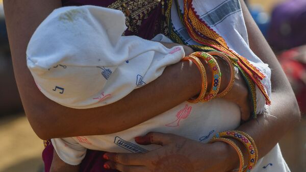 Une Indienne tient un bébé dans ses bras - Sputnik Afrique