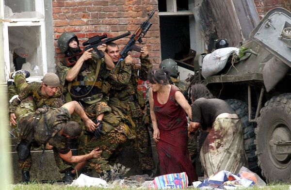 Après avoir conduit les otages dans le bâtiment, les terroristes ont commencé à installer des engins explosifs improvisés remplis de vis et de clous. Ils les ont suspendus au plafond, disposés sur des chaises et par terre, à côté des enfants. Par mesure d'intimidation, plusieurs otages ont été abattus sous les yeux de tout le monde. Sur la photo: opération de sauvetage des otages à Beslan, le 3 septembre 2004. - Sputnik Afrique