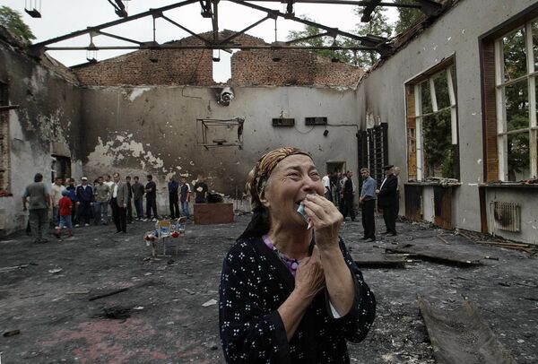 Le 3 septembre, vers 13 heures, deux puissantes explosions ont retenti dans l'école. Une partie du bâtiment s'est effondrée. Une fusillade a commencé. À ce moment-là, 30 otages ont réussi à s'échapper. Les terroristes ont tiré dans le dos des femmes et des enfants en fuite. Sur la photo: une femme pleure dans l'école n°1 détruite à Beslan à la suite de l'attentat terroriste.    - Sputnik Afrique