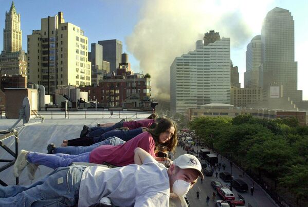 Le vol UA 175 d’United Airlines a percuté la tour sud WTC2 au niveau des étages 78-85 vers 9h03. Sur la photo: des gens regardent l’opération de sauvetage après l’attaque terroriste du 11 septembre depuis le toit d’un immeuble rue Greenwich Street à New York.  - Sputnik Afrique