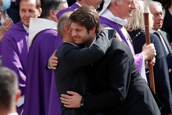 Paul Belmondo, fils du défunt, embrasse son fils Alessandro après la fin de la messe de l’enterrement de Jean-Paul Belmondo. - Sputnik Afrique