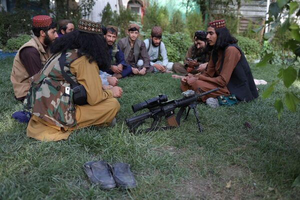 Selon les dirigeants talibans*, les femmes devraient «donner la vie au peuple afghan» et enseigner l'éthique islamique aux enfants. Sur la photo: des talibans* se reposent sur la pelouse d'un parc d'attractions à Kaboul.  - Sputnik Afrique